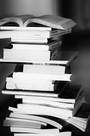 頂部有一本打開的書的高高書堆 — POCO Pad 壁紙