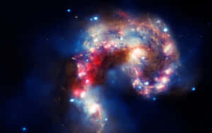 在深空中，碰撞的星系散發出紅色、金色和藍色色調的壯麗景象。 — 星雲 壁紙