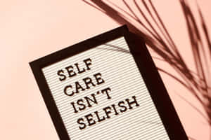 字母板寫著 self care isn't selfish，粉紅牆上有棕櫚葉影子。