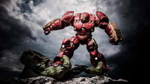 Hulkbuster玩具在風暴雲下的岩石懸崖上站在Hulk玩具之上。 — 復仇者聯盟 壁紙