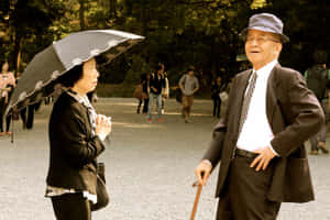 一對年長夫婦在日落時分的公園裡交談。 — 廟宇 壁紙