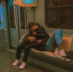 一對情侶在溫暖燈光的車廂內的地鐵長椅上親吻。 — 可愛情侶 GIF 壁紙