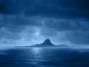 月光下，山島從霧氣瀰漫的海洋中升起，夜空烏雲密佈。 — 月光 壁紙
