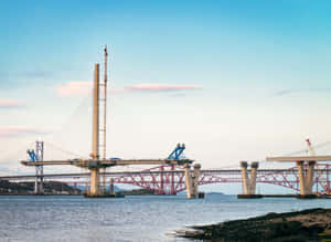 一座正在建造的大橋橫跨河流，背景中有另一座橋。 — 建築 壁紙