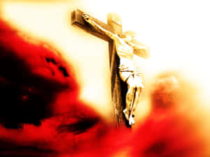 一座 crucifixion 雕像，背景是火紅與金色的天空。