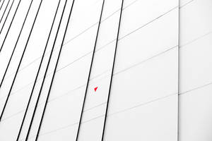 現代建築牆壁，帶有黑色對角線和一個小紅色三角形。 — 電腦 GIF 壁紙