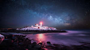 一座發光的紅色燈塔，位於雪島上，在星空下，銀河可見。 — 夜空 壁紙
