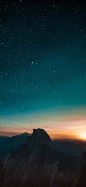 在星光燦爛的暮色天空下，山峰襯著發光的地平線。 — iPhone 12 Pro GIF 壁紙