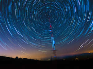 黃昏時分旋轉星軌下的無線電塔 — 燈塔 壁紙
