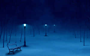 雪地公園長椅在夜晚發光的街燈下，有光禿禿的樹木和星星 — 冬天桌面 壁紙