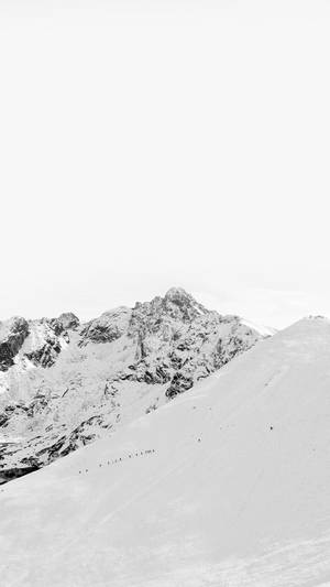 細小的登山者在灰色天空下攀登白雪覆蓋的山脊。 — 白色美學gif 壁紙