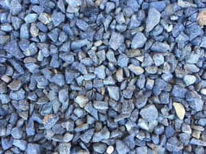 灰色礫石特寫，具有粗糙質感和土色調。 — 深藍色 壁紙