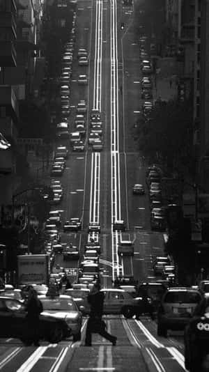 一條繁忙的城市街道，有汽車和行人，黑白風格。 — 日落大道 壁紙
