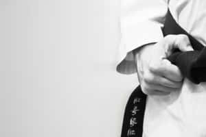 一位武術家的手拿著一條帶有日本文字的黑帶。 — Surface Pro 壁紙