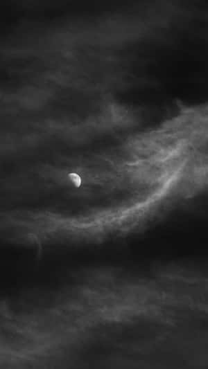 新月穿過烏雲閃耀，營造出陰鬱的夜空。 — 月色夜空 壁紙