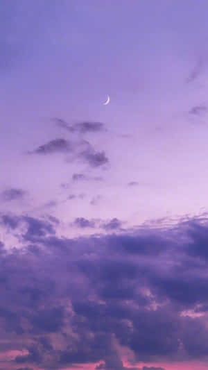 帶有月牙和柔和雲朵的紫色暮色天空 — 紫色 iPhone 壁紙