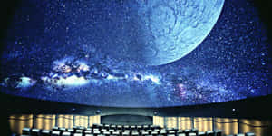 弧形天花板的禮堂，顯示星星、月亮和星系 — 月色夜空 壁紙