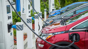 在陽光明媚的戶外停車場插入充電站的電動車。 — 酷車 壁紙