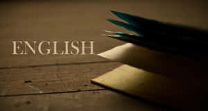 一張標有English的木桌上放著羽毛筆和舊書。 — 美景 壁紙
