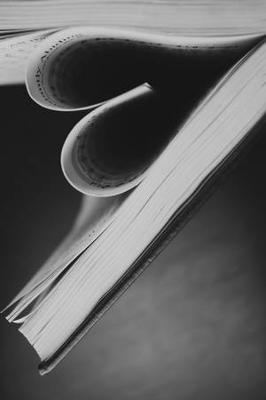 打開的書的特寫，書頁捲曲，以黑白顯示文字。 — 書籍 壁紙