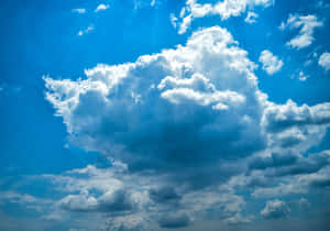 廣闊的藍天，有一朵巨大的蓬鬆白雲，陽光穿透其中。 — 天氣 壁紙