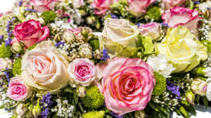 特寫一個色彩繽紛的花卉佈置，包含玫瑰和綠色植物。 — 5120x2880 壁紙