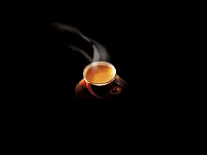 在黑色背景上，一杯發光的茶冒著蒸氣。 — 簡單 壁紙
