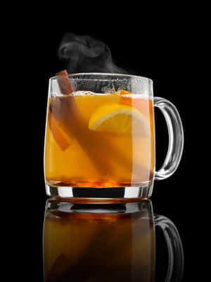 冒著蒸氣的香料蘋果酒杯，配以肉桂和檸檬，置於反光黑色表面。 — 3:4 壁紙