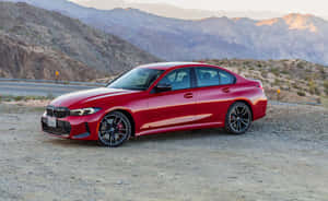 日落時分，紅色BMW M3房車停在沙漠山脈附近的碎石上。 — Steam Deck OLED 壁紙