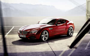 紅色BMW Z4跑車停泊在混凝土上，背景有山。 — Steam Deck 壁紙