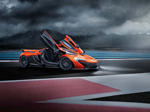 在風暴天空下的賽道上，橙色McLaren跑車打開車門。 — 麥拿侖 GIF 壁紙