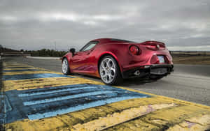 紅色Alfa Romeo 4C跑車在賽道邊緣，天空多雲。 — Steam Deck 壁紙