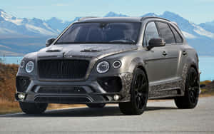 啞灰色 Bentley Bentayga SUV 迷彩，停泊喺山同湖邊。 — MacBook Pro 13 壁紙