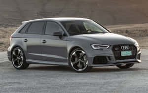 灰色Audi RS3 Sportback停泊喺碎石上，附近係沙漠山丘。 — Steam Deck OLED 壁紙