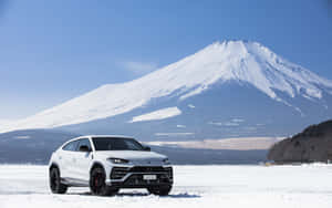 白色林寶堅尼Urus停泊在雪地上，背景為富士山。 — MacBook Air M1 壁紙