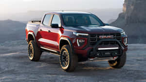 紅色GMC Sierra AT4 pickup貨車在黃昏時停泊在沙漠地形上。 — 黃昏 壁紙