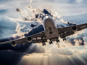 一架大型商用飛機在多雲的天空中飛行，陽光穿透雲層。