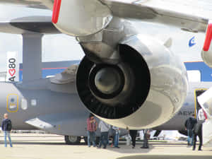 灰色軍用運輸機引擎，人們在航空展觀看。