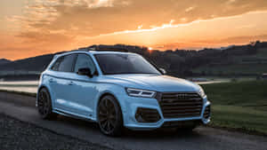 日落時分，淺藍色 Audi SQ5 SUV 停泊在風景如畫的鄉村道路上。 — 奧迪 GIF 壁紙
