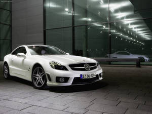 白色 Mercedes SLR McLaren 跑車夜間停泊在玻璃建築前。 — 汽車 壁紙
