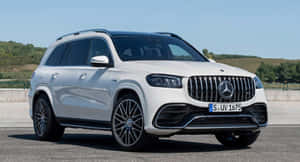 白色Mercedes GLS SUV停泊在道路上，背景有綠色山丘。 — 酷車 壁紙