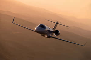私人飛機在金色日落時飛越沙漠 — MacBook Pro 16 壁紙