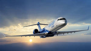 一架CRJ-900 NextGen飛機在帶有雲層的日落天空背景下飛行。 — 日出 壁紙