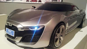 展廳中展示的銀色未來感跑車，配備發光車頭燈。 — 酷車 壁紙