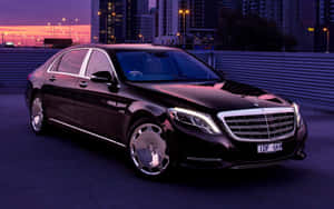 日落時分停泊在城市屋頂上的黑色豪華 Mercedes-Maybach S600。 — MacBook Air M1 壁紙