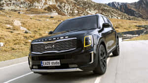 黑色Kia Telluride SUV在岩石背景的山路上 — 現代汽車 壁紙