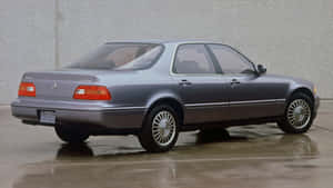 銀色Acura Legend房車停泊在濕滑路面，混凝土牆背景。 — 明亮 壁紙