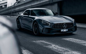 啞光灰色梅賽德斯-AMG GT R停在天橋下的城市道路上。 — 黑色動態圖 壁紙