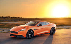 橙色Aston Martin跑車在日落時分停泊在賽道上。 — Steam Deck OLED 壁紙