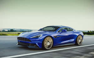 藍色Aston Martin在鄉村高速公路上飛馳，帶有動態模糊效果。 — Steam Deck OLED 壁紙